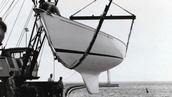 On the George Cuthbertson-designed Red Jacket, seen here at her launching in the spring of 1967, the keel has finally become a distinct appendage in its own right, although it would be another year before the keel and ballast became a single entity. Red Jacket’s builder, Erich Bruckmann, is holding the tag line behind the crane.