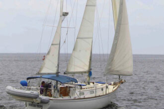A low-aspect, well-balanced sail plan enables the Pearson 365 ketch to stand up in a blow, above. Lindsey Sailors, at left, and her husband, Don, command their Schurr Thing from an elevated custom swiveling helm seat.