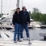 man and woman standing on a sailboat