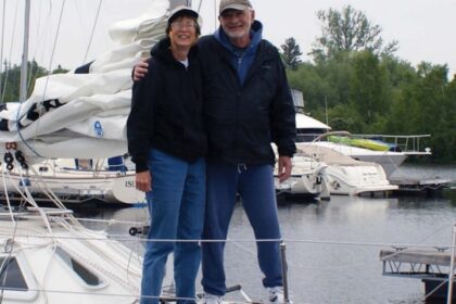 man and woman standing on a sailboat