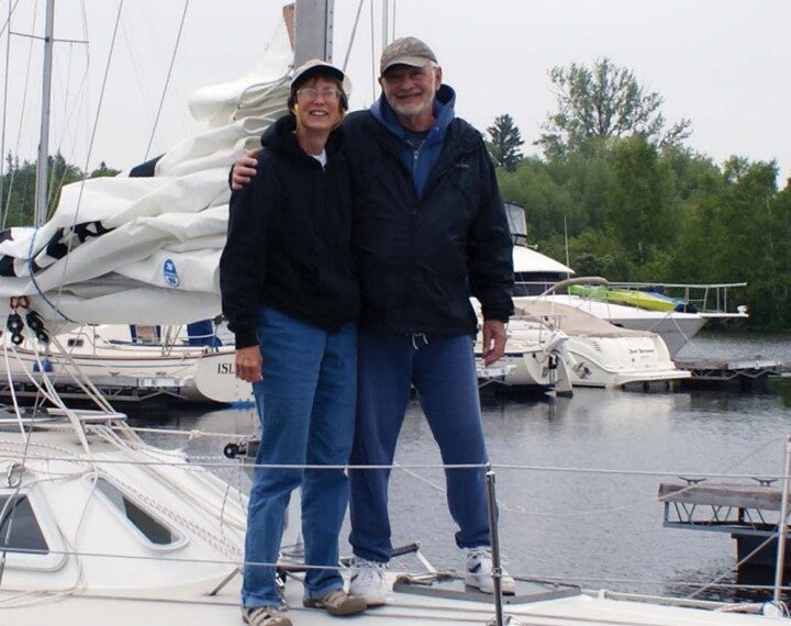 man and woman standing on a sailboat