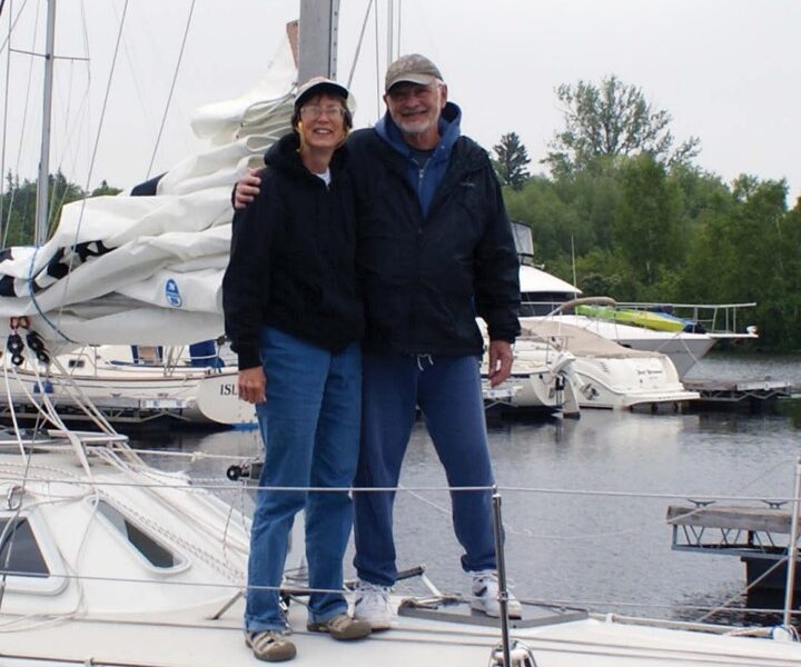 man and woman standing on a sailboat