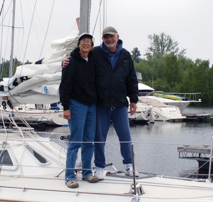 man and woman standing on a sailboat