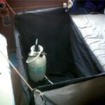 Cliff’s Paceship PY 26 had no shower, so he rigged an outdoor grill cover to fit between the saloon settees and uses a garden sprayer.