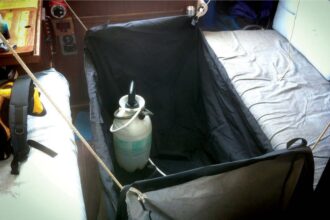 Cliff’s Paceship PY 26 had no shower, so he rigged an outdoor grill cover to fit between the saloon settees and uses a garden sprayer.