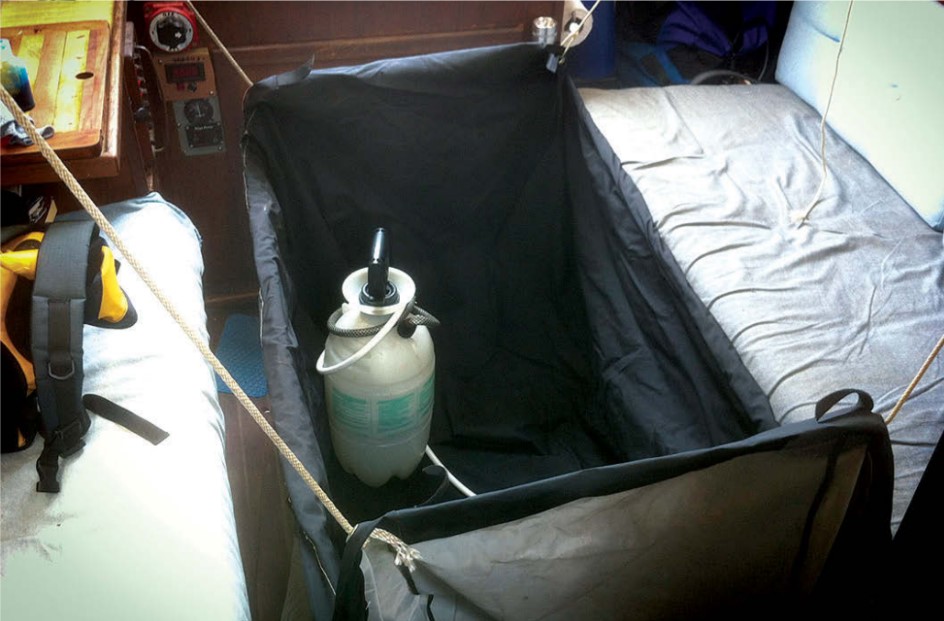 Cliff’s Paceship PY 26 had no shower, so he rigged an outdoor grill cover to fit between the saloon settees and uses a garden sprayer.