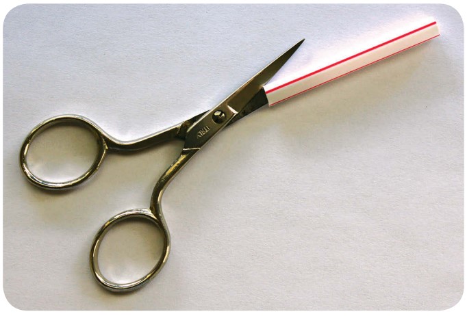 cutting drinking straw with scissors