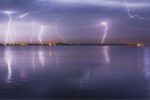 Photo of a lightning storm over water