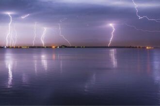 Photo of a lightning storm over water