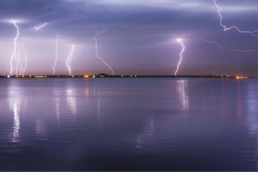 Photo of a lightning storm over water