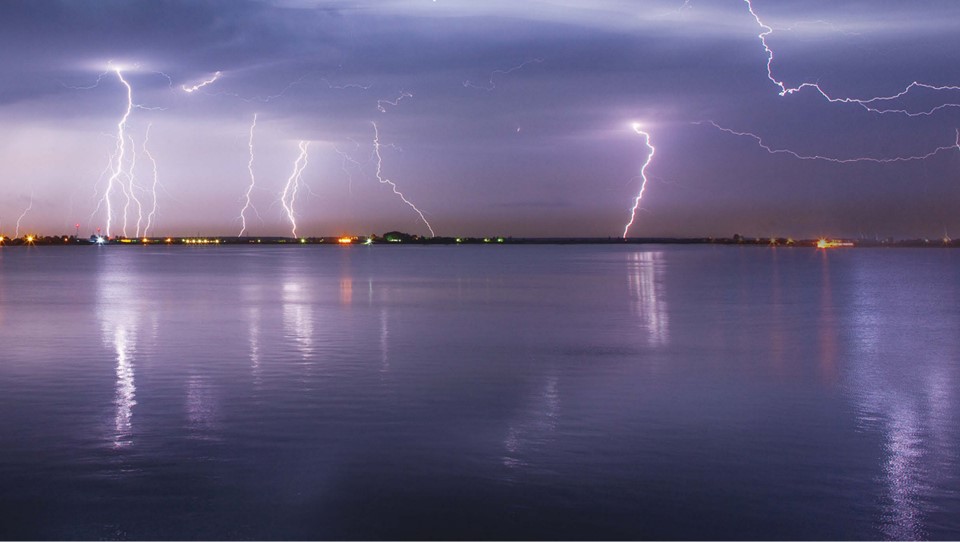 Photo of a lightning storm over water