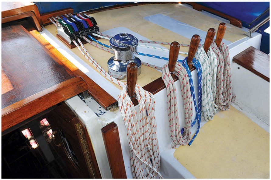 Six lines lead through fairleads to rope clutches and a winch on the starboard-side rope deck, where a pinrail keeps them tidy.