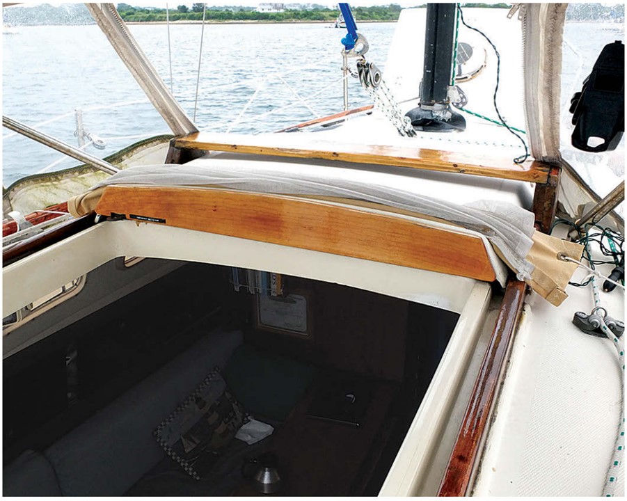 When the bugs are not around, Cliff rolls up his screen and stows it forward of the hatch slide. Cords tied to the handrails hold it in place.