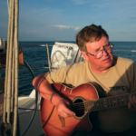 A picture of a man playing the guitar