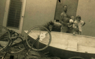 Dad, Boo Boo, and I pose with the dinghy he built in the living room.
