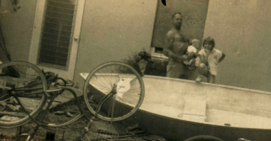 Dad, Boo Boo, and I pose with the dinghy he built in the living room.