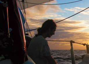 A man sitting on a boat at sunset