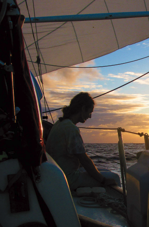 A man sitting on a boat at sunset