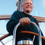 A man at a boat helm