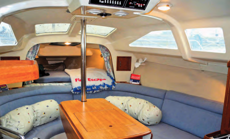 The V-berth is accessed with some difficulty by climbing over the large and inviting U-shaped settees. Note the extensive use of molded fiberglass liners and the absence of space-dividing bulkheads.