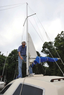 After raising the mast, Brooks prepares Wing Ding II’s mainsail for hoisting.