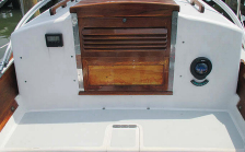 The depth sounder and compass are mounted on the cockpit bulkhead, above. The VHF is down below. John uses a hand-held GPS. Another compass fits on centerline in a bracket installed in the bridge deck.
