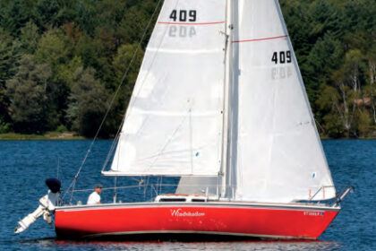 Vermont’s Lake Memphremagog provides a verdant background for Windshadow, a Capri 25. Her owners, Rob and Bonnie Geisler, below, restored her (and her color) from a “largely ignored” condition.