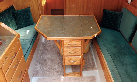 The saloon table has drawers built into its base and a support for the extending starboard settee berth.