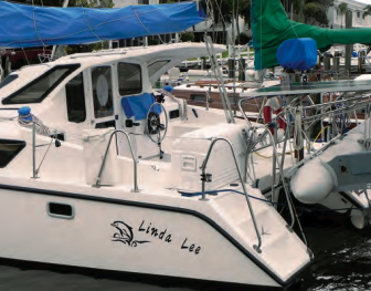 The stern of Linda Lee is a busy place, with an inflatable in davits, a solar panel, a barbecue grill, and lines for handling the retractable rudders.