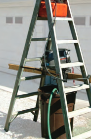 Perry’s outboard-motor test rig uses a few items from the garage. Hanging the motor inside the stepladder ensures the rig is stable.