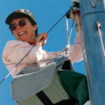 A woman climbing a boat mast