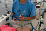 A woman holding pliers on a boat