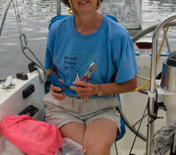 A woman holding pliers on a boat