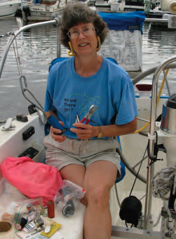A woman holding pliers on a boat