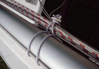 To fasten his rigging to the mast for trailering his boat, Allen passes the bungee loop around the mast and through itself, then forms a smaller loop to hold the rigging (visualize a figure eight). the finished tie-up holds the rigging away from the mast and reduces chafe.