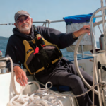 A man sitting at a boat helm