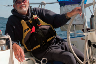 A man sitting at a boat helm