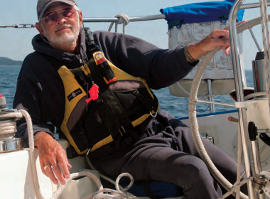 A man sitting at a boat helm