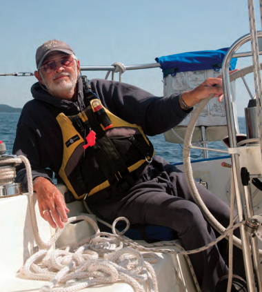 A man sitting at a boat helm