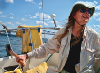 Sailing against a background of fair-weather clouds, Roy’s wife, Dawn Saunders, takes the helm of Laughing Dolphin on the final leg of the delivery, which took them up the Hudson River to Lake Champlain.