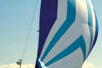 Mystic, a C&C 30, shows off her pert sheer while sailing under the spinnaker her owners, Good Old Boat’s Karen Larson and Jerry Powlas, built from a Sailrite kit. The kayak they use for ship-to-shore excursions and exploring takes up some deck space but doesn’t hamper the sailing activities.