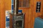 Burry’s diesel fireplace awaits the New York winter. The heat shield protects the bulkhead from heat given off by the flue all the way up to the headliner. The damper halfway up is needed for gusty winds.
