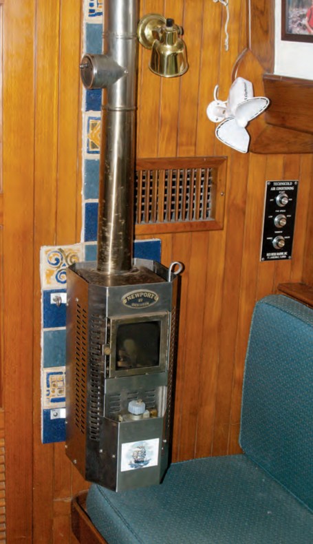 Burry’s diesel fireplace awaits the New York winter. The heat shield protects the bulkhead from heat given off by the flue all the way up to the headliner. The damper halfway up is needed for gusty winds.