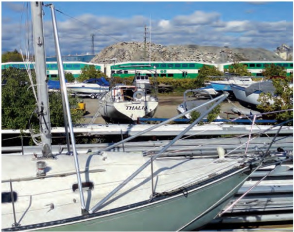 When the mast reaches its fully vertical position, it remains supported by the A-frame while the shrouds are connected to the chainplates.