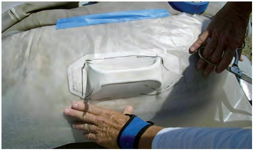 With rough cutouts made to fit around handles and other fittings, the pattern can be fitted on the dinghy.