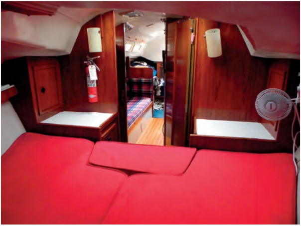 The V-berth measures 80 inches by 70 inches. This view, looking aft from the V-berth into the saloon, shows the stowage areas and counter surfaces in the forward cabin.