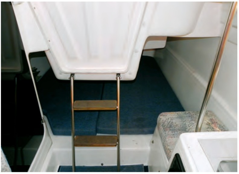 With only two persons on board, the cavernous berth under the cockpit often ends up the repository for duffel bags, loose gear, and the somewhat unwieldy companionway dropboard.