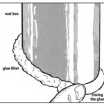 After the PVC pipe has been cut to an angle that keeps it vertical against the hull, it can be set into place with four or five spots of glue. After the glue has hardened a fillet of thickened glue is coved around its base using either the end of a small pipe or a moistened finger.