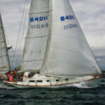 Sailing at speed, an Allied XL 242, a late CCA design, gains sailing length when its long stern overhang becomes immersed.