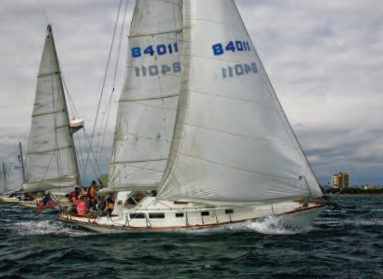 Sailing at speed, an Allied XL 242, a late CCA design, gains sailing length when its long stern overhang becomes immersed.